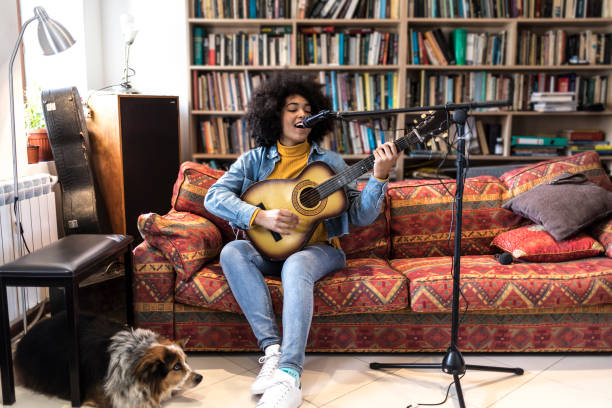 donna africana con un cane che suona la chitarra e canta - singing lesson foto e immagini stock