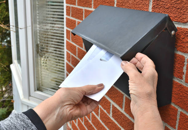 Lifestyle, Front Door Letterbox Lifestyle...This is a close up shot of a home owner, taking several envelopes from a front door, residential, letterbox. junk mail photos stock pictures, royalty-free photos & images