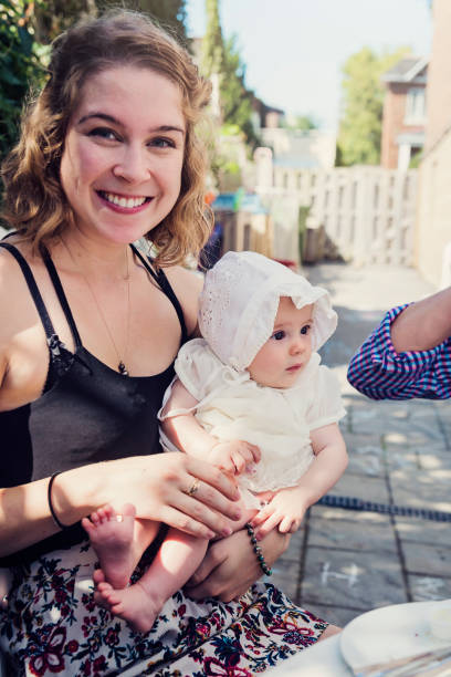 istock Young woman holding baby outdoors in summer. 947061634
