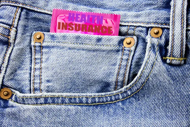 Handwritten text showing Health Insurance. Business concept writing for Medical Healthcare Written on condom pack in small pocket in the pants jeans.