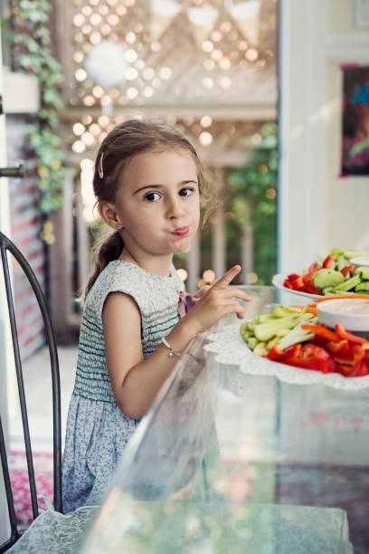 istock Cute little girl eating raw vegetables at a buffet. 947065344