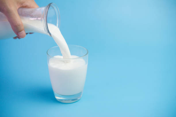 istock Milk in glass blue background 947065456
