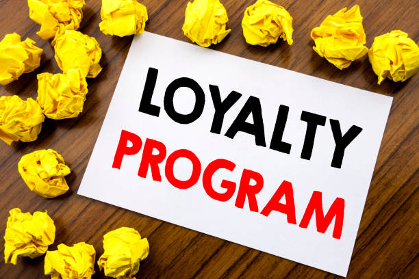 istock Handwritten text showing word Loyalty Program. Business concept writing Marketing Concept Written on sticky note paper, wooden background with space office view with folded yellow paper 947071786