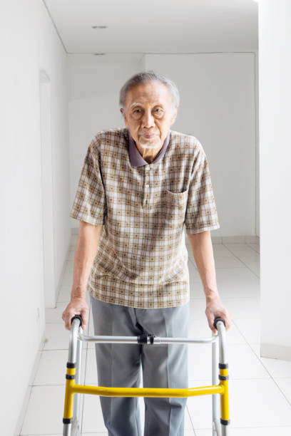 istock Elderly man walking with a walker at home 947076092