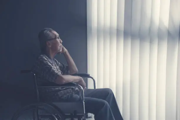 Photo of Sad lonely senior man sitting on wheelchair
