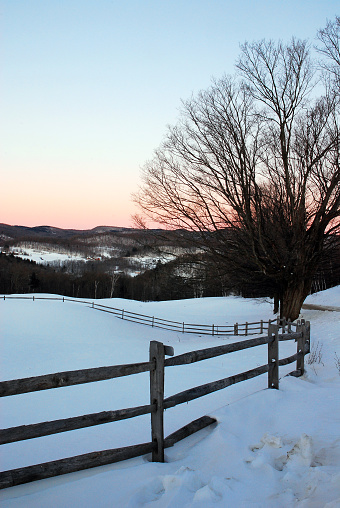 Dawn begins to shed light on a rural Vermont winter scene
