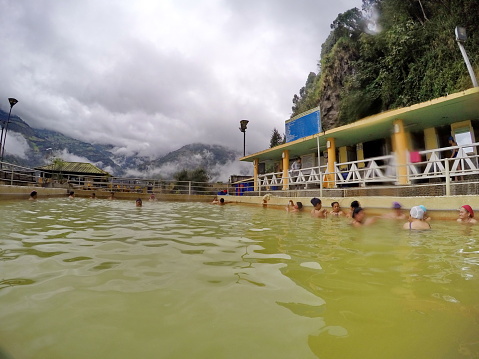 Ecuadorian people in the mineral water of a natural hot spring in Banos, Ecuador