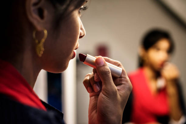 Indian woman putting on a lipstick Indian woman putting on a lipstick sri lankan culture photos stock pictures, royalty-free photos & images