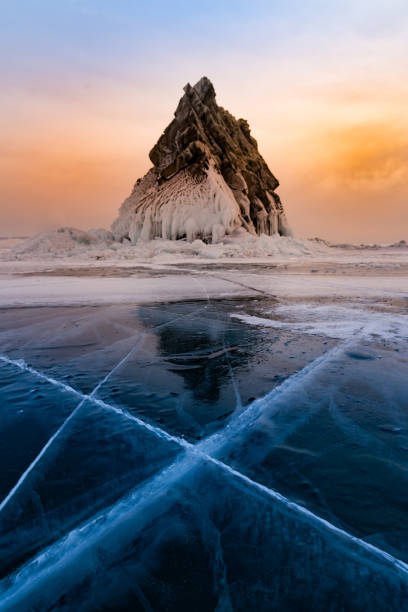 istock Sunset sky over frozen water lake and stone 947089162