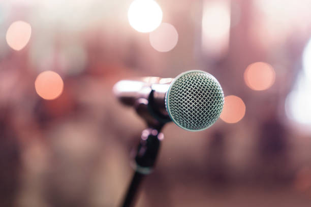 istock Close up microphone on stage in concert hall restaurant or conference room. Blurred background. Copy space 947102464