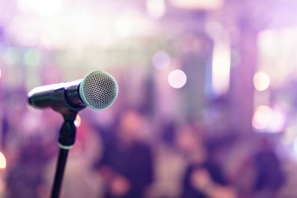 istock Close up microphone on stage in concert hall restaurant or conference room. Blurred background. Copy space 947102516