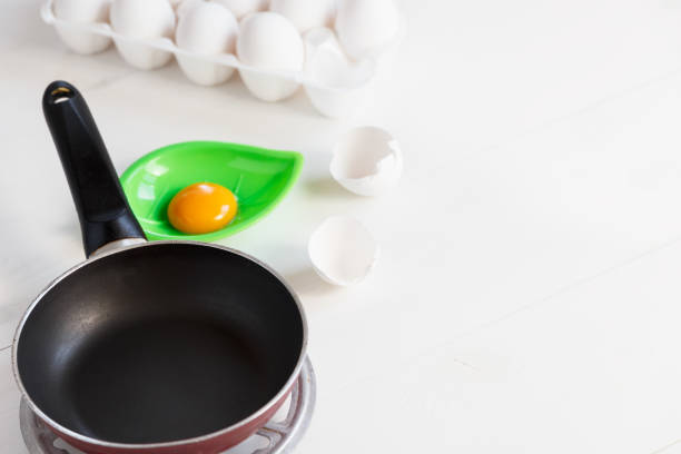 Frying pan and eggs on white boards. Concept of a healthy breakfast. Copy space