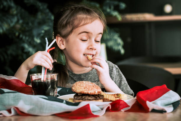 istock little girl in cafe with burger 947111358