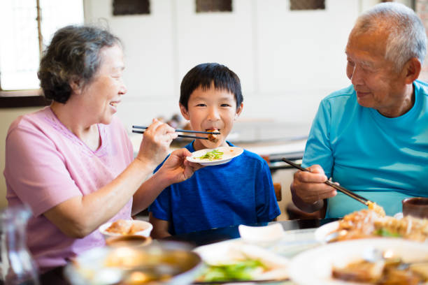 Grandmother feeding her grandson in restaurant Grandmother feeding her grandson in restaurant chinese ethnicity china restaurant eating stock pictures, royalty-free photos & images