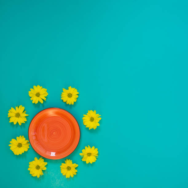 istock Summer background - a red plate surrounded by yellow chrysanthemum flowers 947115062