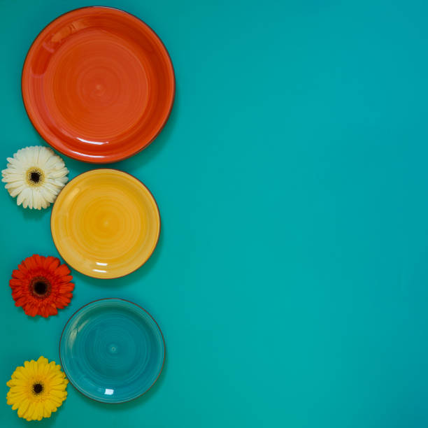 istock Summer background - three colorful plates with three flowers 947115090
