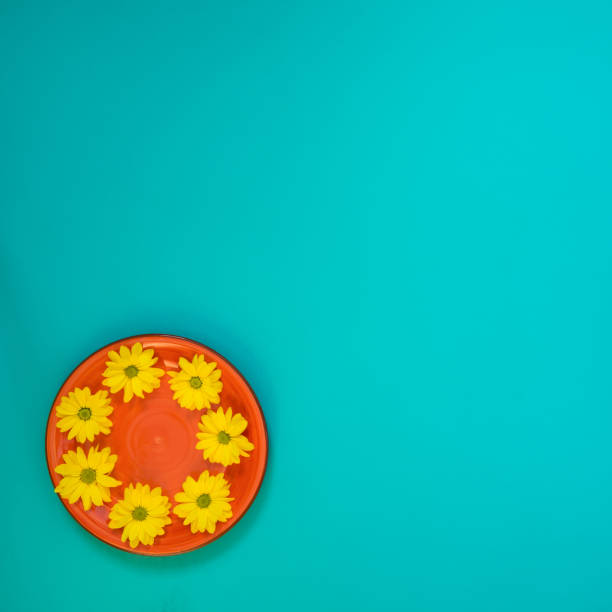 istock Summer background - a red plate with yellow chrysanthemum flowers 947115092