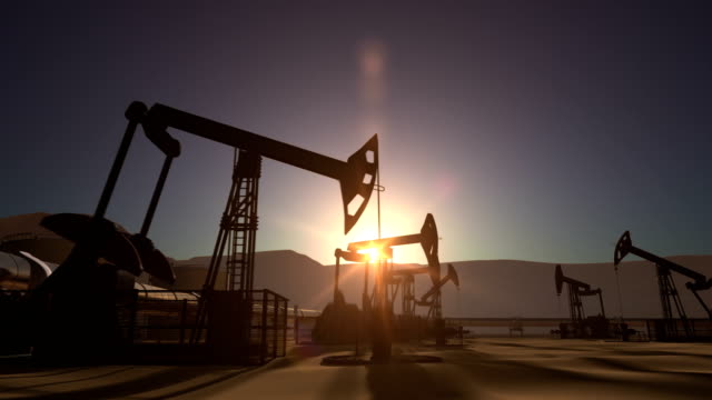 Sunrise over oil field with pumpjacks and pipeline