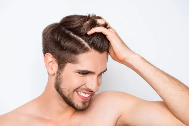 Photo of Portrait of smiling man showing his healthy hair without furfur