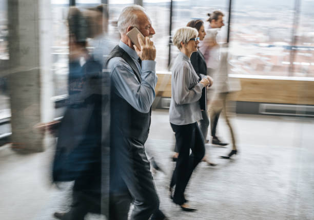 istock Large group of entrepreneurs walking in a hallway in blurred motion. 947138084