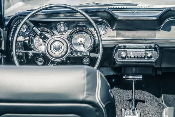 Photo of Close-up, detailed photo of the interior, dashboard, steering wheel and speedometer of a classic oldtimer american muscle car