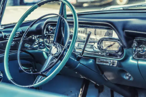 Photo of Close-up, detailed photo of the interior, dashboard, steering wheel and speedometer of a classic oldtimer luxury sports car