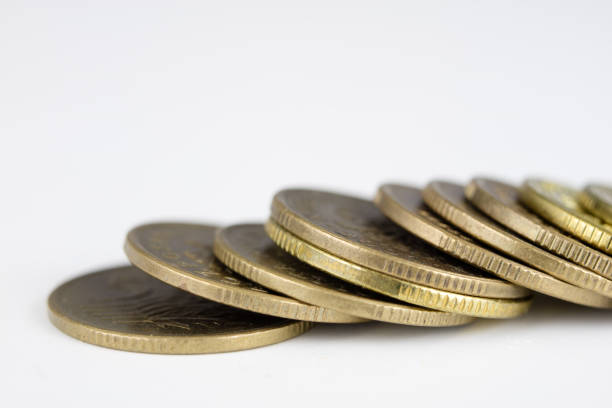 Coins stacked. Money lying on the table. White background.