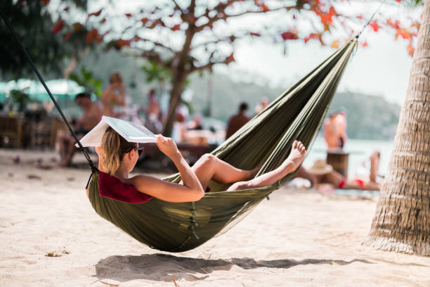 istock Woman relaxing in beach hammock and protecting her head from a sun. 947144282