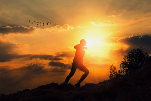 istock Fit man running against sunrise 947144776