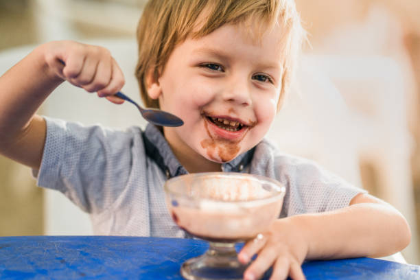 istock Happy little boy enjoying in ice-cream at a cafe. 947145266