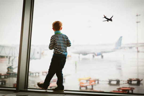 istock little boy waiting in airport looking at planes 947147914