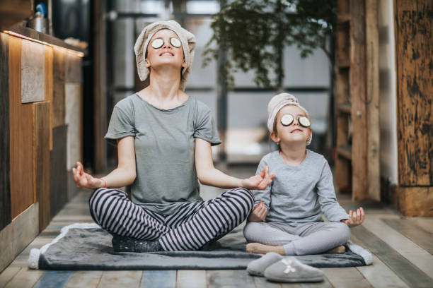 madre e figlia rilassate che esercitano yoga al mattino a casa. - spirituality yoga zen like meditating foto e immagini stock