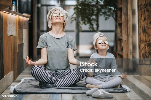 istock Relaxed mother and daughter exercising Yoga in the morning at home. 947148590