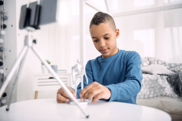 istock Earnest boy blogger showing toy 947149220