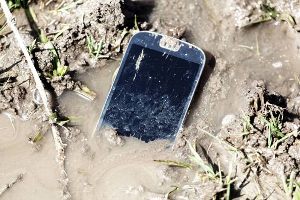 istock Mobile phone in brown mud with water 947151724