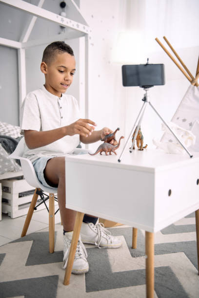 istock Energetic boy blogger using dinosaurs toys 947151804