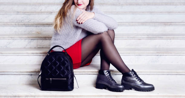 Model woman legs in black boots with bag. Young woman legs in silver boots with black bagpack. Trendy hipster outfit style. Model sitting on stairs pantyhose stock pictures, royalty-free photos & images