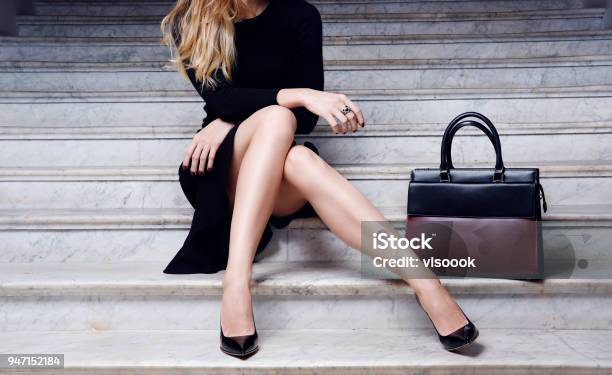 Modelo En Vestido Negro Con Zapatos De Tacón Alto Bolso Grande Foto de stock y más banco de imágenes de Mujeres