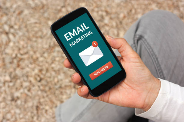 istock Hand holding smart phone with email marketing concept on screen 947152750