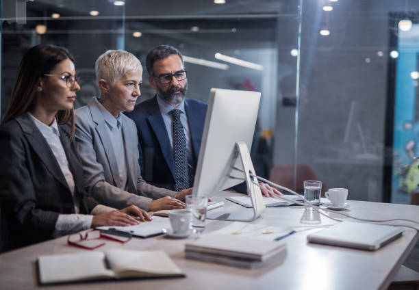 istock Group of focused business people working on desktop PC in the office. 947155790