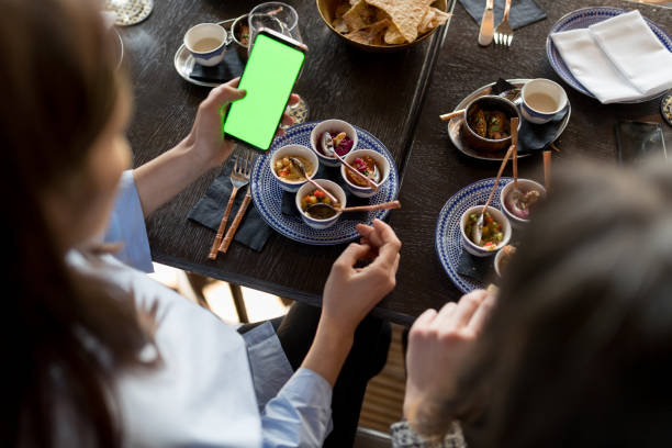 istock Elevated view of coworkers in restaurant using smart phone with green screen 947156576
