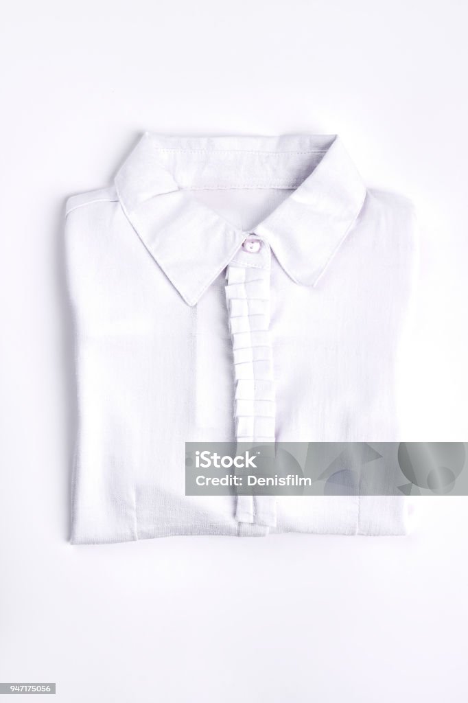 White woman shirt on white background. White woman shirt on white background. New folded cotton blouse for school girls. New collection of modern cotton shirts for girls. Blouse Stock Photo