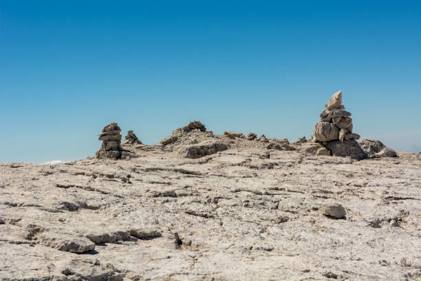 istock Pyramide built of rocks to guide lost mountaineers. 947192446