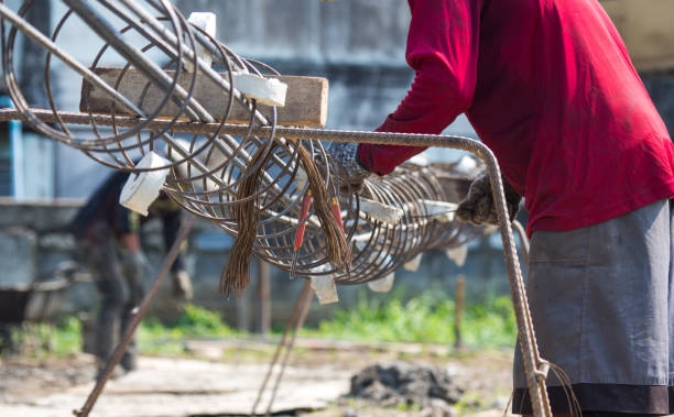 istock workers hands put on gloves using hand to iron wire to tie for structure the house or building. 947193510