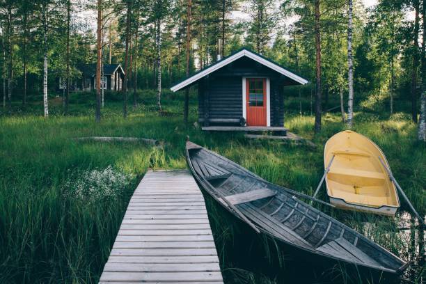伝統的な木造の小屋。湖と釣り船を桟橋にフィンランド式サウナ