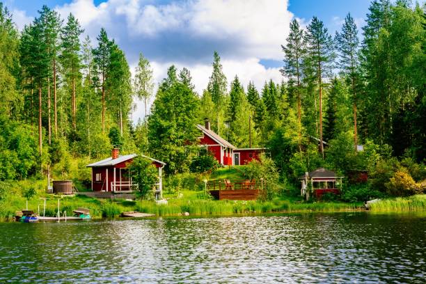 jest to tradycyjny fiński drewniany domek z sauną i stodołą nad brzegiem jeziora. lato wiejskiej finlandii. - finland zdjęcia i obrazy z banku zdjęć