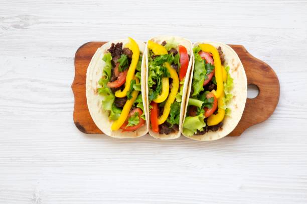 istock Tacos with pork and vegetables . Mexican kitchen. White wooden background. Top view, flat, overhead. 947201916