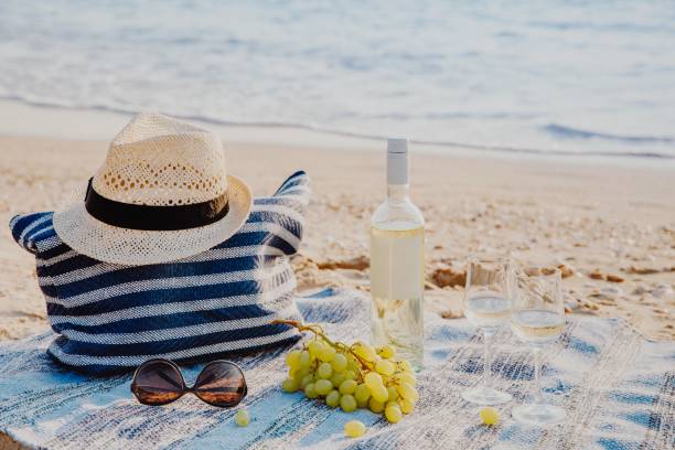 istock Picnic background with bag, grape and white wine by blue sea 947203204