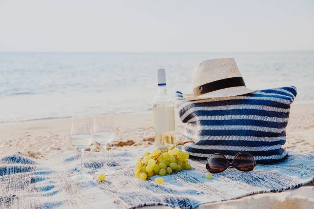 istock Picnic background with bag, grape and white wine by blue sea 947205214