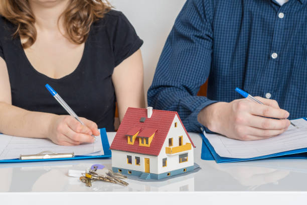 divorce and dividing a property concept. man and woman are signing divorce agreement. - repartição imagens e fotografias de stock